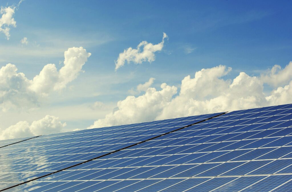 Close up photo of solar panels with clouds in a blue sky